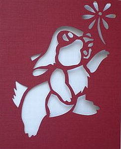 Hand-made cut greeting card with a rabbit with a flower